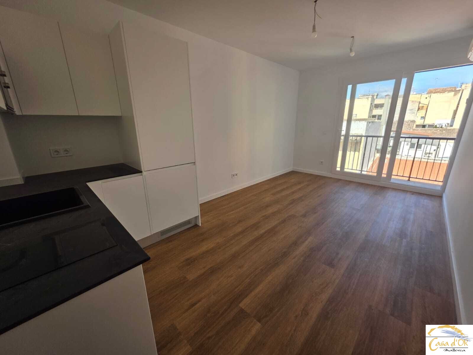  Living room with open kitchen and access to the balcony